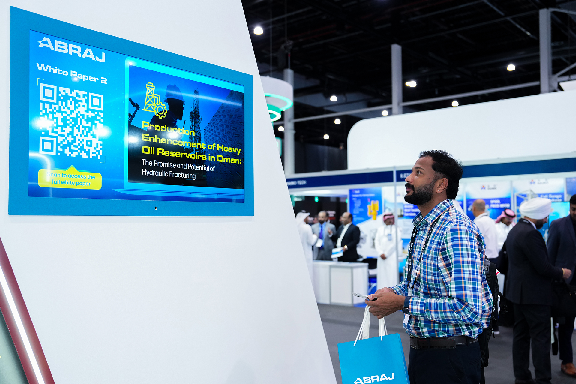 Visitors engaging with Abraj's white papers, highlighting thought leadership at MEOS 2025